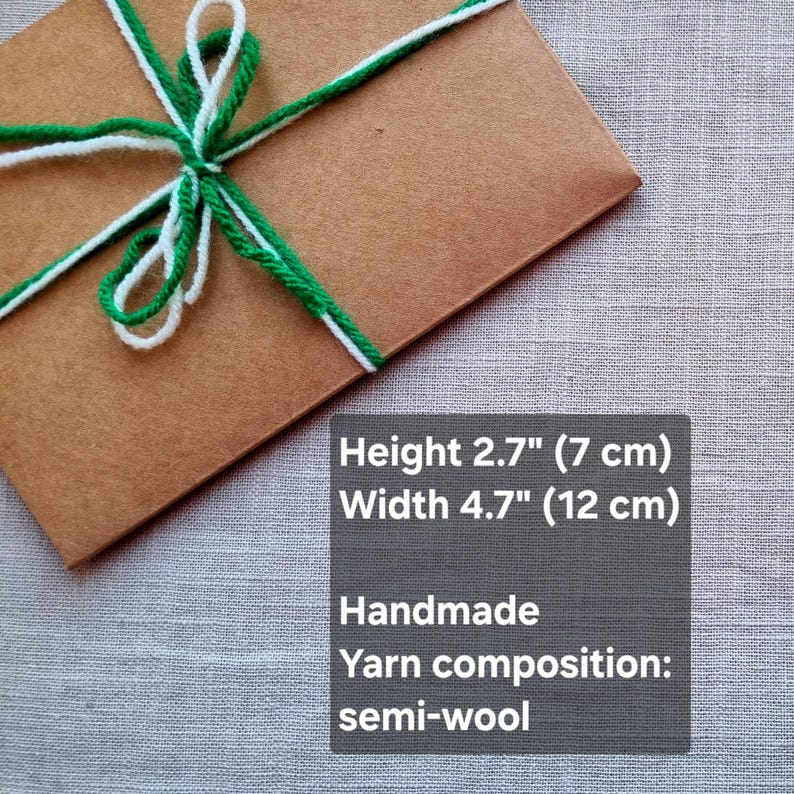 May include: A brown package tied with white and green yarn. The package is 2.7 inches (7 cm) high and 4.7 inches (12 cm) wide. The yarn is semi-wool and the package is handmade.