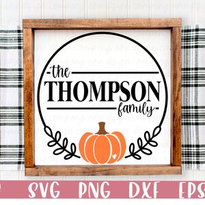 May include: A wooden sign with a circle design featuring the text "the Thompson family" and a stylized pumpkin with a heart in the center.