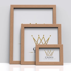 May include: Three wooden picture frames of different sizes, all with a natural wood finish. The largest frame is empty, the middle frame has a gold crown design, and the smallest frame has the text "CROWN PICTURE FRAMES".