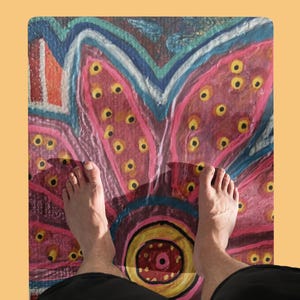 May include: A rectangular floor mat featuring a vibrant, hand-painted style floral design. The pattern displays large, stylized pink petals with yellow centers, accented by blue and orange outlines, creating a bold, colorful, and artistic surface.