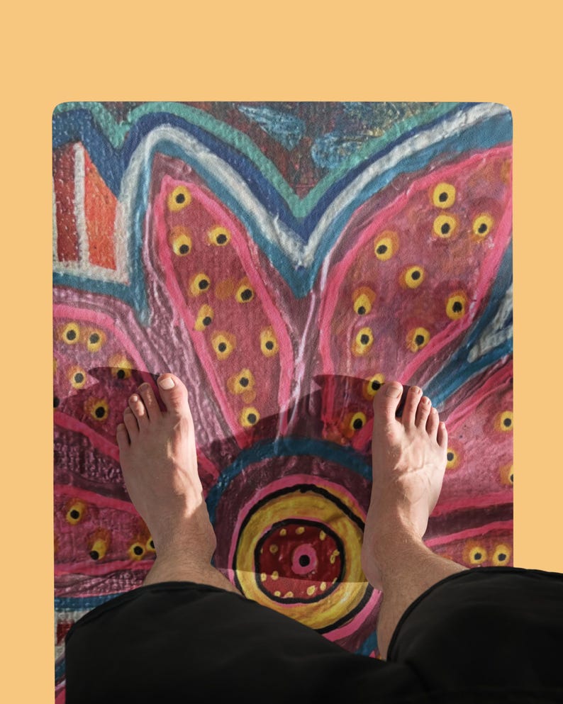 May include: A rectangular floor mat featuring a vibrant, hand-painted style floral design. The pattern displays large, stylized pink petals with yellow centers, accented by blue and orange outlines, creating a bold, colorful, and artistic surface.