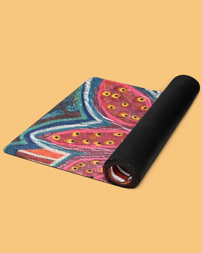 May include: A rectangular yoga mat partially rolled up, featuring a vibrant abstract design with pink, blue, and orange sections. The surface displays a pattern of pink organic shapes filled with small yellow dots, outlined by blue and white lines.