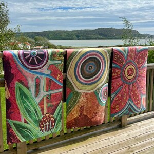 May include: Three rectangular fabric panels featuring vibrant, abstract floral and circular patterns in shades of red, pink, green, and blue. Each panel displays distinct, hand-drawn style motifs, including large petals, concentric circles, and organic shapes.