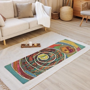 May include: A rectangular yoga mat featuring a vibrant, abstract design with a large central spiral in shades of dark brown, teal, and yellow. The pattern includes a heart-shaped motif, wavy lines, and dotted accents in red, pink, and gold tones.