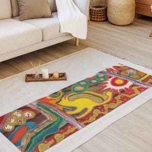 May include: A rectangular area rug featuring a vibrant, multi-colored abstract design. The pattern includes a prominent yellow cat figure, a bright red sun, and various swirling shapes in shades of green, blue, red, and gold, with textured details.