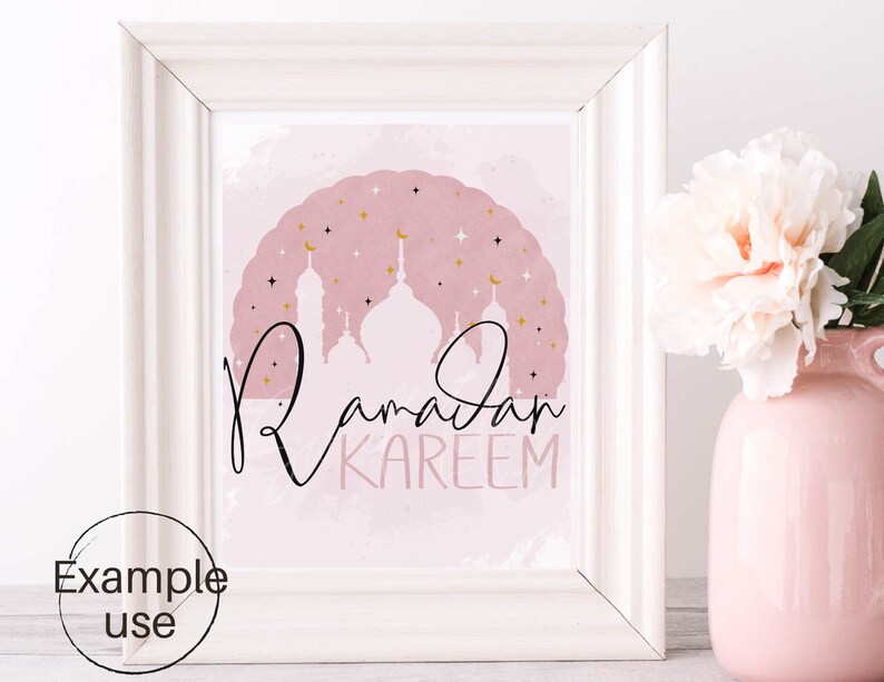 May include: A printable art print with a pink watercolor background and gold stars. The print features a silhouette of a mosque with the text "Ramadan Kareem" in black calligraphy.