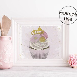 May include: A white cupcake with pink and gold frosting and a gold mosque topper. The cupcake is decorated with pink macarons, gold sprinkles, and a pink flower. The background is a light pink watercolor wash with gold glitter.