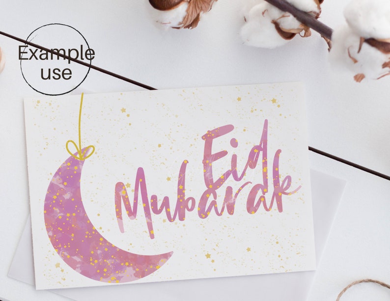 Op de afbeelding: Een wenskaart met de tekst "Eid Mubarak" in roze script, vergezeld van een roze halve maan met gouden sterren. De kaart heeft een witte achtergrond met gouden spikkels en ligt op een witte ondergrond.