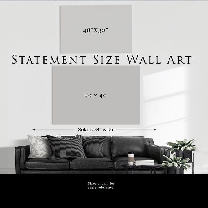 a statement size wall art, which is 60 x 40 inches wide. The artwork is displayed on a wall, and there is a black and white couch in the foreground.
