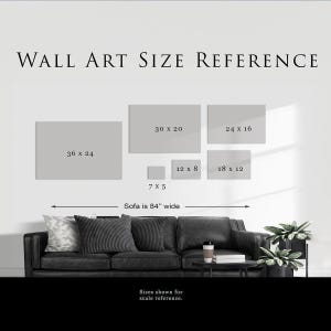 a wall art reference for a living room, with a black couch and a potted plant in the background. The reference provides sizes for various artworks, including square and rectangular pieces, and indicates that the sofa is 84 inches wide.