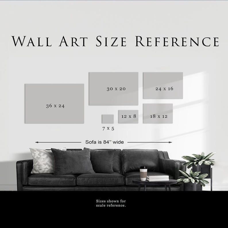 a wall art reference for a living room, with a black couch and a potted plant in the background. The reference provides sizes for various artworks, including square and rectangular pieces, and indicates that the sofa is 84 inches wide.