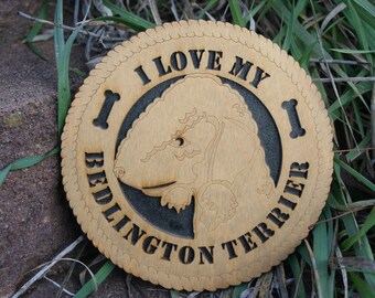 May include: A wooden coaster with a black and white design. The design features a Bedlington Terrier dog and the text "I love my Bedlington Terrier".