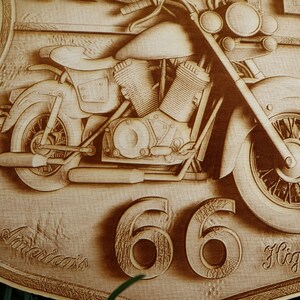 May include: A wooden sign with a carved image of a motorcycle. The sign is shaped like a shield and has the text "America's Highway 66" on it.