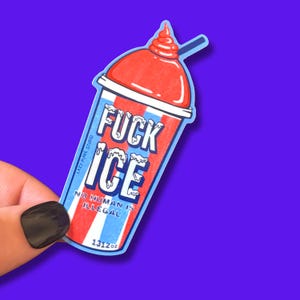 May include: A sticker featuring a cartoon slushie with red, white, and blue stripes. The text on the sticker reads "FUCK ICE" and "NO HUMAN IS ILLEGAL". The sticker also has the text "1312oz" and "LAZY MADE STUDIO".