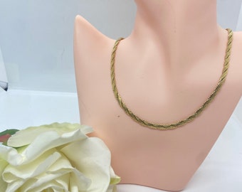 May include: A gold-toned chain necklace with a twisted rope design. The necklace is displayed on a mannequin bust.