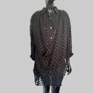 May include: Black sheer button-down shirt with a geometric pattern. The shirt is draped and has a loose fit.