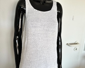 May include: White crochet tank top with a loose fit and a scoop neck.