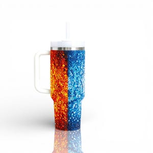 Puede incluir: Un vaso grande y aislado con asa, tapa y pajita blancas. El vaso est&aacute; dividido verticalmente, con un lado cubierto de pedrer&iacute;a naranja y roja y el otro de pedrer&iacute;a azul. La base del vaso refleja los colores.