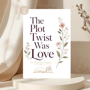 Pode incluir: Um cartão branco com o texto "The Plot Twist Was Love" em uma fonte bordô escura, adornado com ilustrações florais. O cartão inclui a frase "For Your Next Chapter" e uma imagem de um livro aberto.