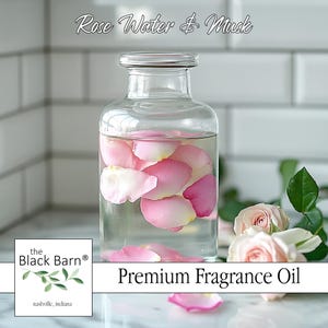 May include: A white ceramic mug with a black handle and the text "But First, Coffee" in a black, handwritten-style font. The mug is on a white surface.