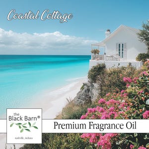 May include: Scenic image of a white coastal cottage overlooking a turquoise ocean and white sand beach. The sky is blue with fluffy clouds. Pink flowers and green foliage frame the cottage. Text reads "Coastal Cottage" and "Premium Fragrance Oil".