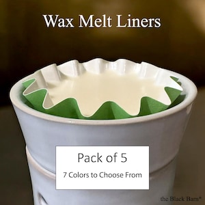May include: A close-up of a white ceramic wax warmer with a green and white wax melt liner. The liner contains a light-colored wax. Text on the image reads "Wax Melt Liners", "Pack of 5", and "7 Colors to Choose From".