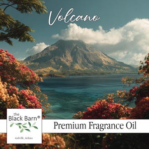 May include: A scenic landscape featuring a volcano, blue water, and vibrant red and orange flowers. The text "Volcano" is written in cursive. The bottom right corner reads "Premium Fragrance Oil". The Black Barn logo is in the bottom left corner.