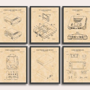 May include: A set of six vintage-style patent drawings for video game consoles and controllers. The drawings are in black and white and feature various angles of the consoles and controllers. The drawings are framed in black frames and have a beige background.