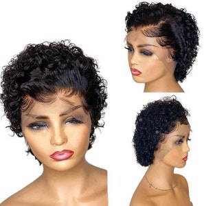 May include: A short, curly black wig with a lace front. The wig is styled in a pixie cut with loose curls. The wig is on a mannequin head with a neutral makeup look.