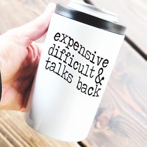 May include: White can cooler with black text that reads "expensive difficult & talks back".
