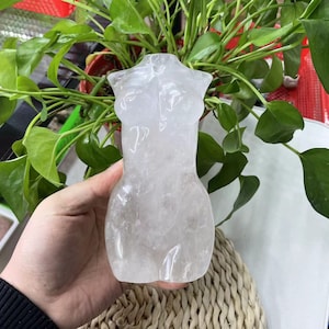 May include: A white crystal sculpture in the shape of a human torso.