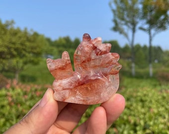 May include: A red and clear crystal carving of a phoenix, a mythical bird that symbolizes rebirth and renewal.