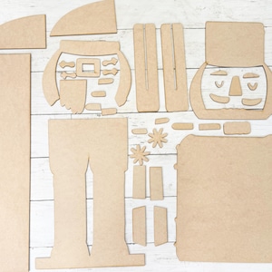 May include: A set of wooden craft pieces for creating a nutcracker figurine. The pieces are in various shapes and sizes, including the head, body, legs, arms, and hat. The pieces are made of unfinished wood and are ready to be painted or stained.