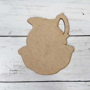 May include: A wooden cutout of a pitcher with a handle and a wide base. The cutout is unfinished and ready to be painted or stained.