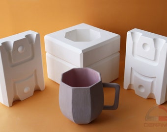May include: Three white ceramic molds for making a mug. The molds are stacked on top of each other. A purple mug is in the center of the image.