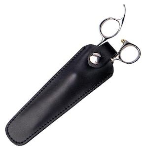 May include: Silver-coloured hair shears with curved handles and a small gold-coloured screw, in a black leather sheath. The sheath has a snap closure and is stitched along the edges.