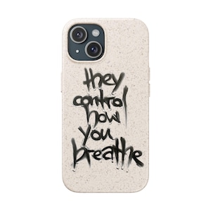Puede incluir: Funda de teléfono beige con un mensaje negro estilo grafiti que dice "they control how you breathe". La funda tiene una superficie texturizada y un recorte para la cámara. La funda está diseñada para un smartphone.