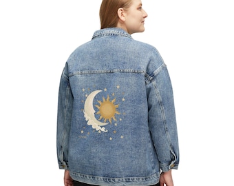 Puede incluir: Una chaqueta de mezclilla azul de tono medio con un gráfico en la espalda de un sol dorado y una luna creciente de color crema rodeados de pequeñas estrellas. La chaqueta tiene un cuello clásico, mangas largas con puños abotonados y cierre frontal.