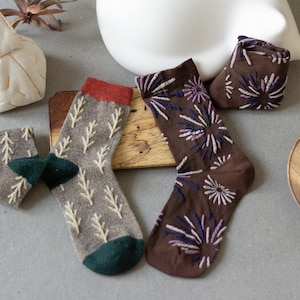 May include: A set of three ceramic mugs with a speckled, matte finish. Each mug is a different colour: light blue, cream, and grey. The mugs have a simple, modern design and a comfortable handle. Ideal for coffee or tea.