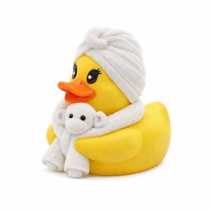 Op de afbeelding: Een gele rubberen eend met een witte handdoek-turban en een witte sjaal met een kleine aap. De eend heeft een oranje snavel en zwarte ogen met wimpers. Een leuk en grillig item.