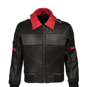 Könnte beinhalten: Eine schwarze Lederbomberjacke mit rotem Kragen und roten Akzenten an den Ärmeln. Die Jacke hat einen Reißverschluss und einen gerippten Bund und Rippbündchen.