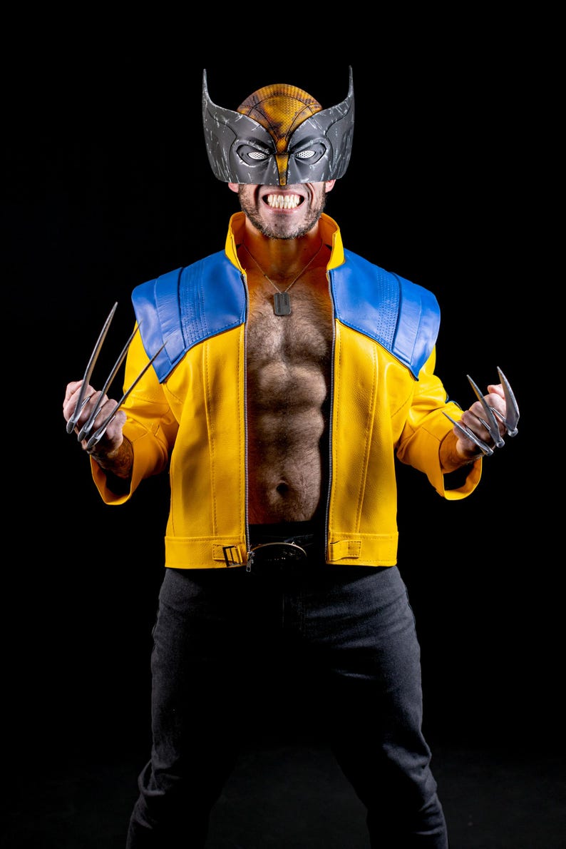 May include: A person dressed as Wolverine, wearing a yellow and blue jacket, a black mask with a silver skull, and holding silver claws in each hand.