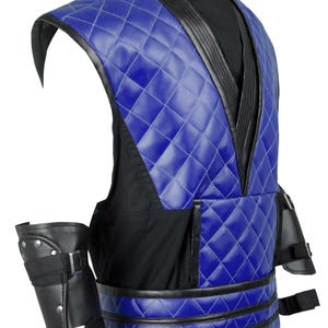 Puede incluir: Un chaleco acolchado azul y negro con un cintur&oacute;n negro y protectores de brazo a juego. El chaleco tiene cuello en V y un patr&oacute;n de diamante.