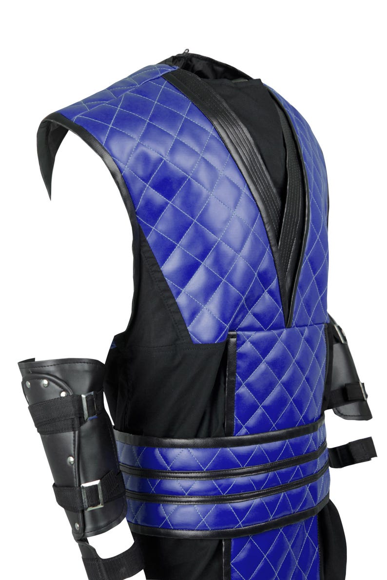 Puede incluir: Un chaleco acolchado azul y negro con un cintur&oacute;n negro y protectores de brazo a juego. El chaleco tiene cuello en V y un patr&oacute;n de diamante.