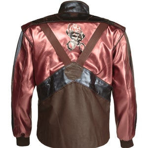 Puede incluir: Una chaqueta de cuero marr&oacute;n con un panel de cuero rosa en la espalda. La chaqueta tiene un cuello de cuero negro y un panel de cuero negro en la parte inferior. La parte posterior de la chaqueta presenta un gr&aacute;fico de una calavera con un casco y las palabras "RED ANTS".