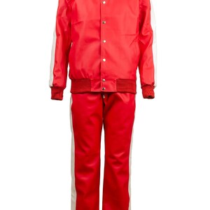 May include: A red tracksuit with white stripes down the sleeves and legs. The jacket has a collar, snap closures, and a ribbed hem and cuffs. The pants have a matching red and white stripe design.