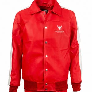 May include: A red jacket with white stripes on the sleeves and a matching red ribbed hem and cuffs. The jacket has a button-up front and a white logo with a bull's head and the text "OX AND BULLS LEATHER COMPANY".