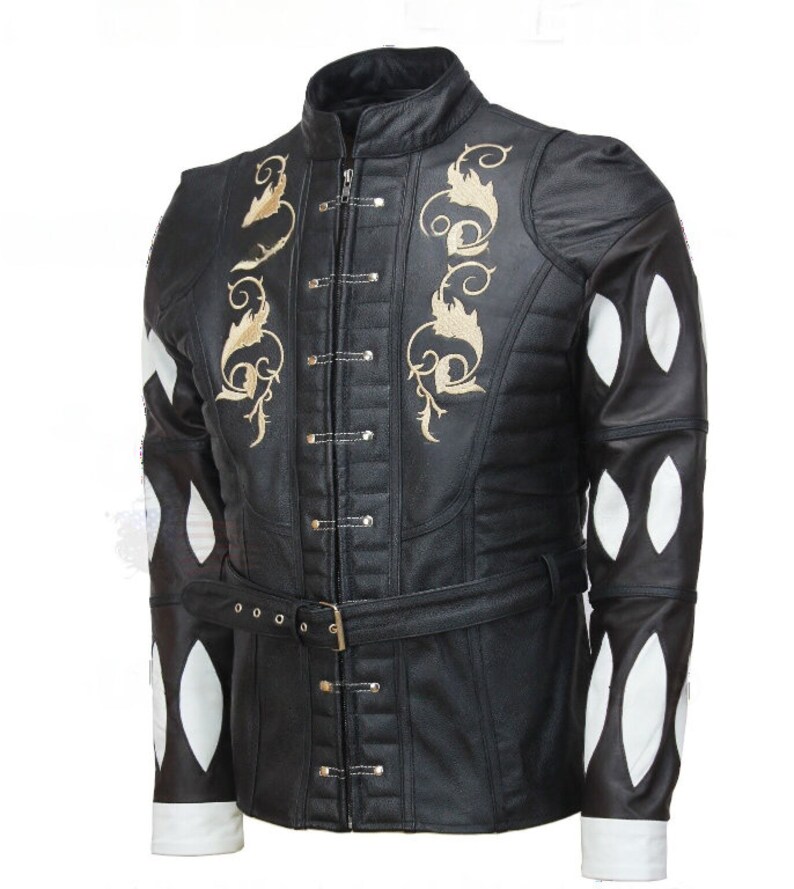 May include: A black leather jacket with a gold embroidered design on the front and white diamond-shaped panels on the sleeves. The jacket has a high collar and a belt.