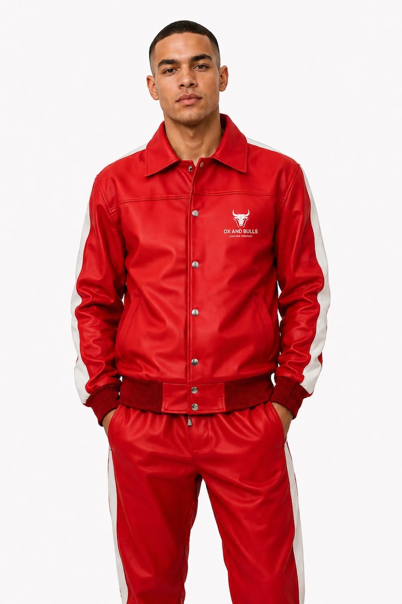 May include: Red leather jacket and matching pants with white stripes. The jacket has white accents on the sleeves and the text "OX AND BULLS" with a bull logo. The outfit is a two-piece set.