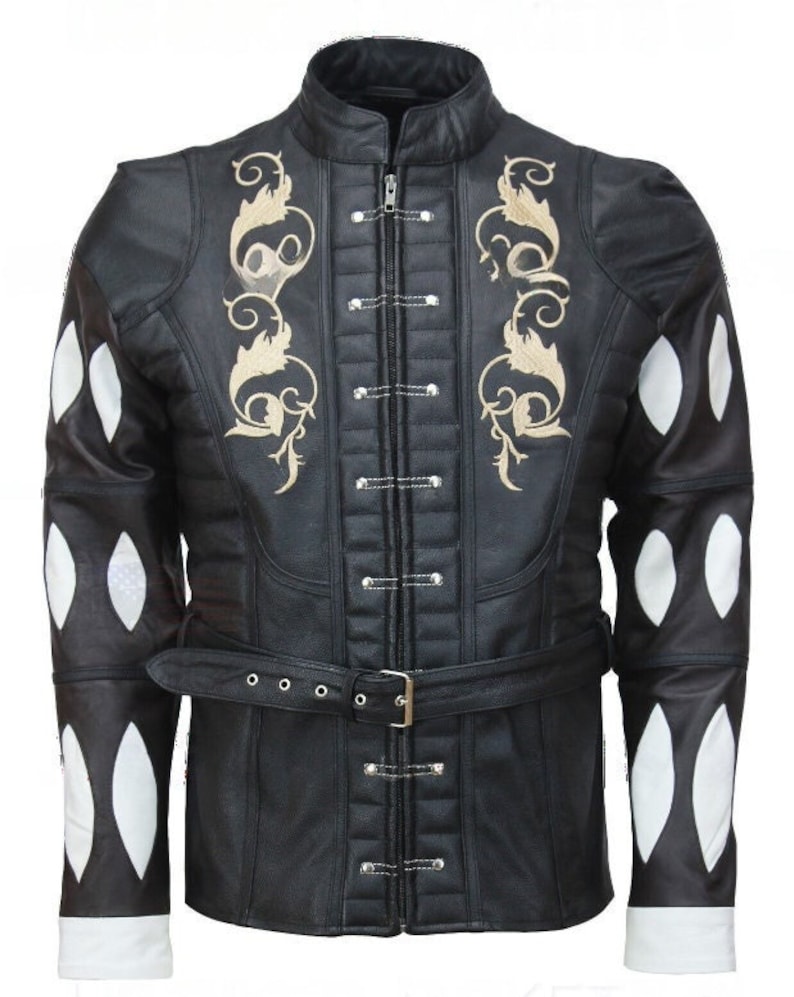 May include: A black leather jacket with a gold embroidered design on the front and white diamond-shaped patches on the sleeves. The jacket has a zipper closure and a belt.